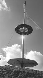 Low angle view of pole on hill against sky