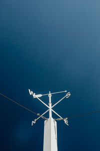 Low angle view of cross against clear blue sky