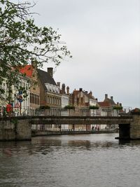 River by buildings in city against sky