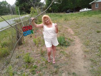 Portrait of woman standing by text on field