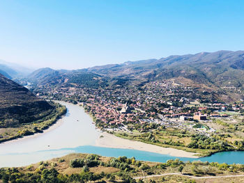 Aerial view of landscape and mountains against clear blue sky