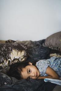Portrait of boy resting on bed at home