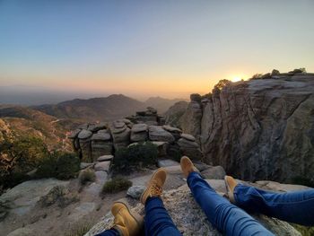 Pov sitting on a cliff at sunset