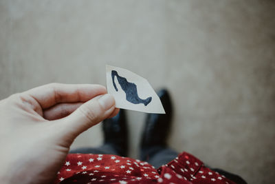 Low section of woman holding paper