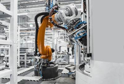 Orange robotic arm in automated factory