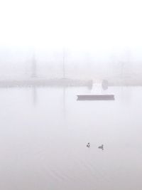 Scenic view of lake against sky during winter