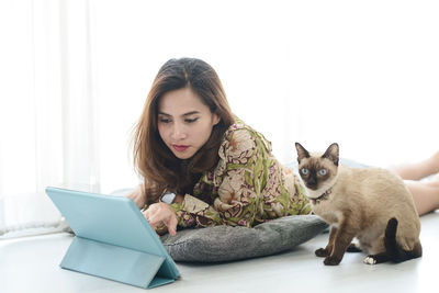 Portrait of young woman with cat