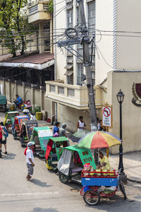 People on street against buildings in city