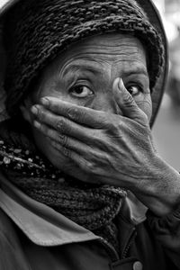 Close-up portrait of woman with hands covering mouth