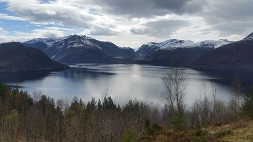 Scenic view of lake by mountains against sky