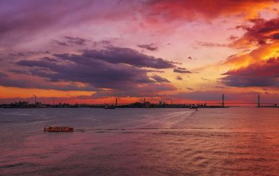 Scenic view of sea against cloudy sky during sunset