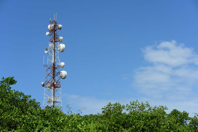 Low angle view of communications tower against blue sky