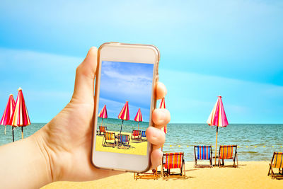 Low section of man relaxing on hammock at beach