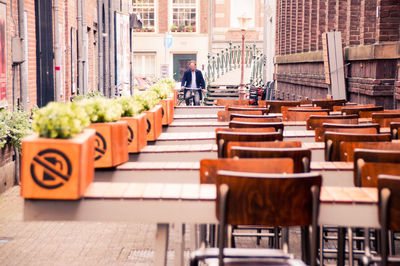 Empty chairs and tables at cafe in city