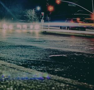 Illuminated city street during rainy season at night