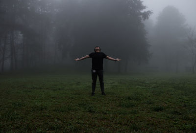 Full length of man standing on field in foggy weather