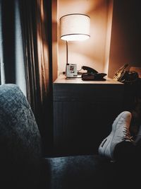 Low section of person in illuminated room at home