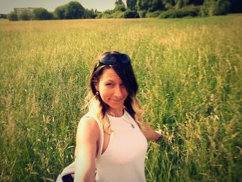 Portrait of smiling young woman standing on field