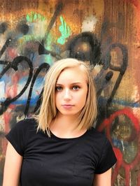 Portrait of teenage girl against graffiti wall