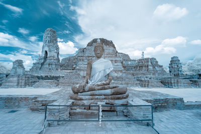 Statue of temple against cloudy sky