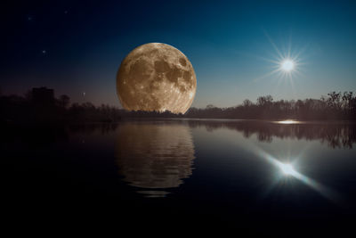 Scenic view of lake against clear sky at night