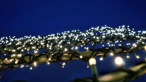 Low angle view of illuminated lights against sky at night