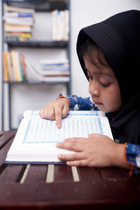 Boy looking at book on table