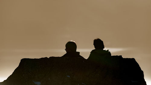 Silhouette people against clear sky