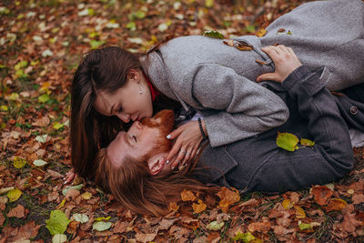 Woman lying on leaves during autumn