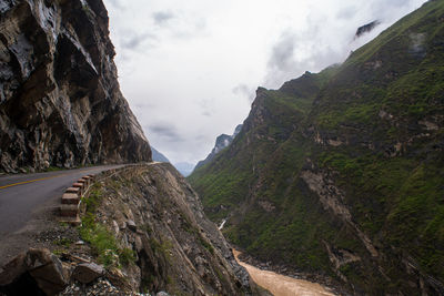 Mountain road at tiger leaping gorge against sky