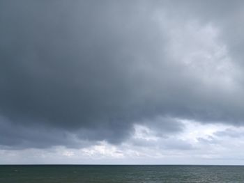 Scenic view of sea against storm clouds