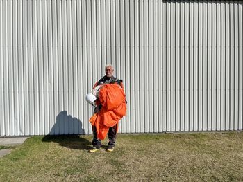 A happy man with orange parachute after landing 