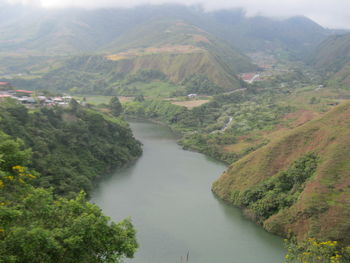 High angle view of river amidst mountains against sky