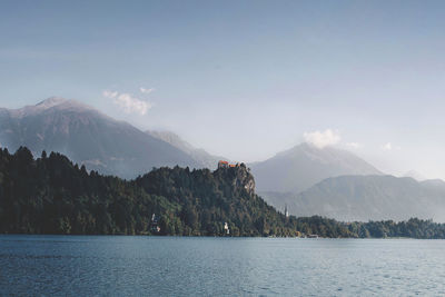 Scenic view of river by mountains against sky