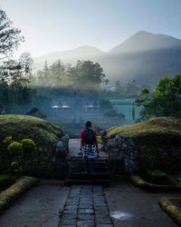 Rear view of people on mountain against sky