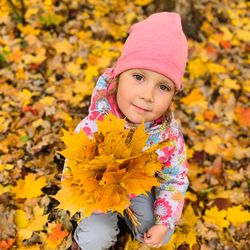 Portrait of cute girl with leaves during autumn