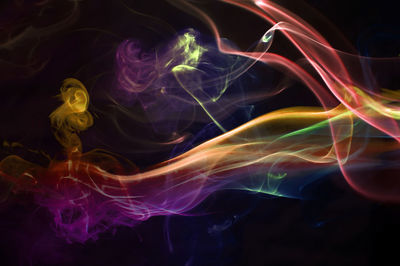 Close-up of colorful abstract smoke pattern against black background