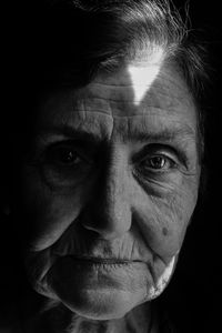 Close-up portrait of senior woman in darkroom