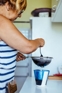Midsection of man holding coffee cup at home