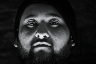 Close-up portrait of man in darkroom