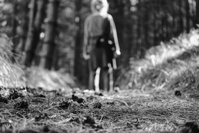 Rear view of woman walking on field