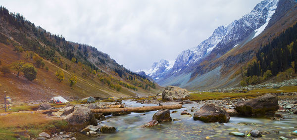 Scenic view of lake by mountains against sky