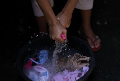 Low section of woman washing clothes at home