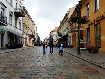 People walking on street in city against sky