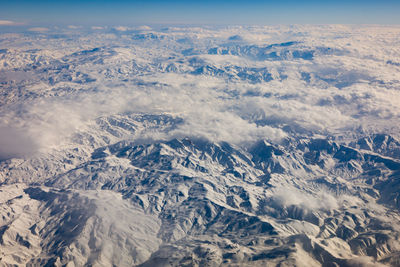 Aerial view of snowcapped mountains against sky