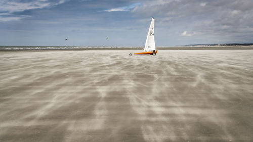 Sailboat on beach against sky