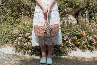 Low section of woman standing by stone wall