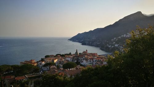 Scenic view of sea by town against clear sky