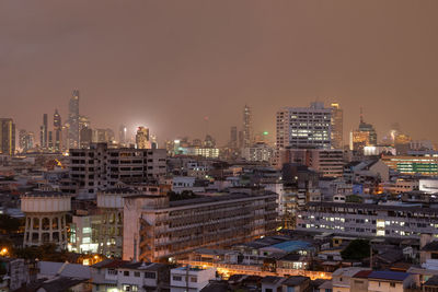 High angle view of illuminated buildings against sky at night