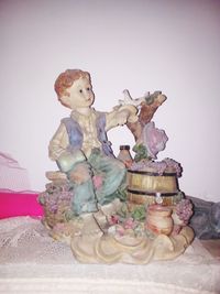 Close-up of figurine on table against wall